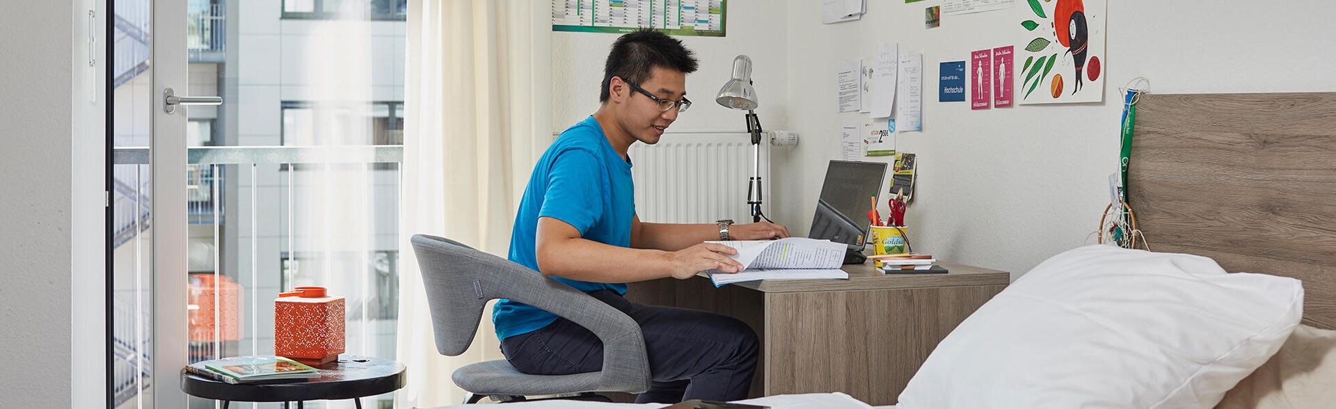 A student studies at a desk in a 1-room flat of the Boardinghaus Esslingen