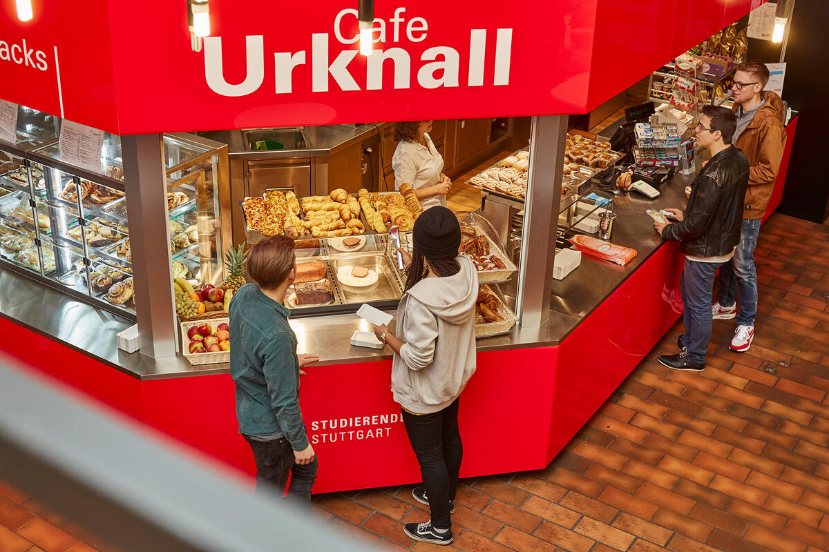 Students stand in front of the sales stand of the Cafeteria Urknall