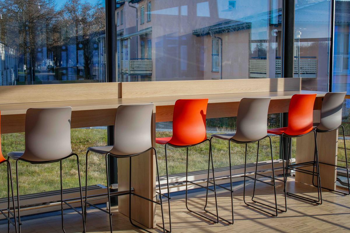 Rote und graue Stühle an einer Theke