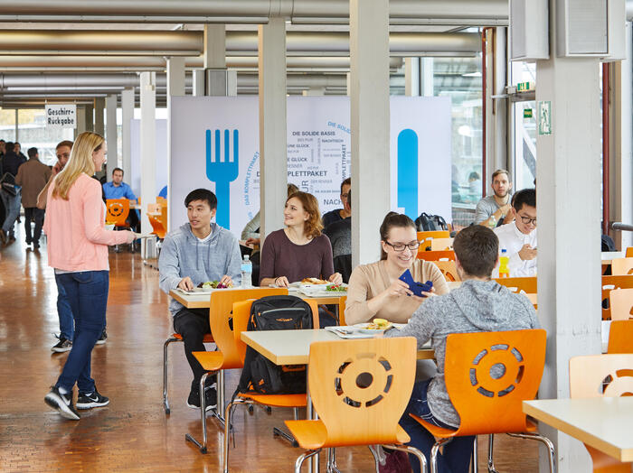 Studierende sitzen im Speisesaal der Mensa Vaihingen.