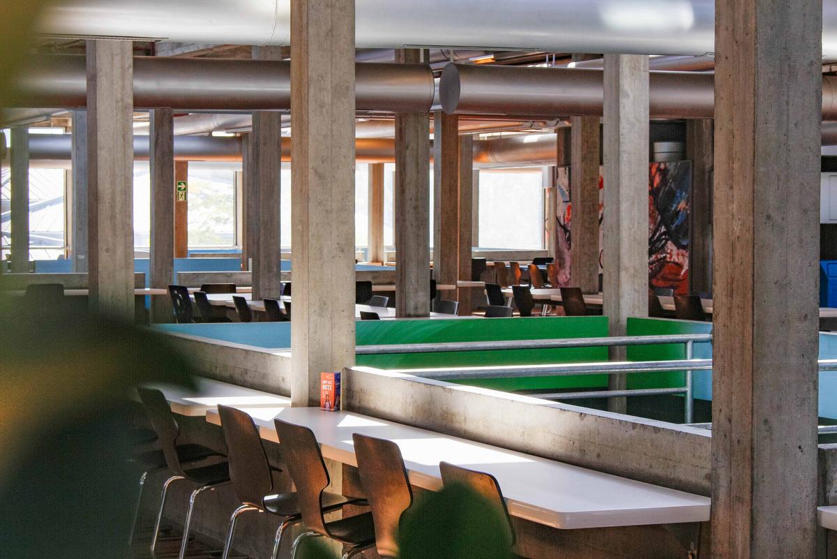 Essensaal mit grauen Säulen, Tische und Stühlen