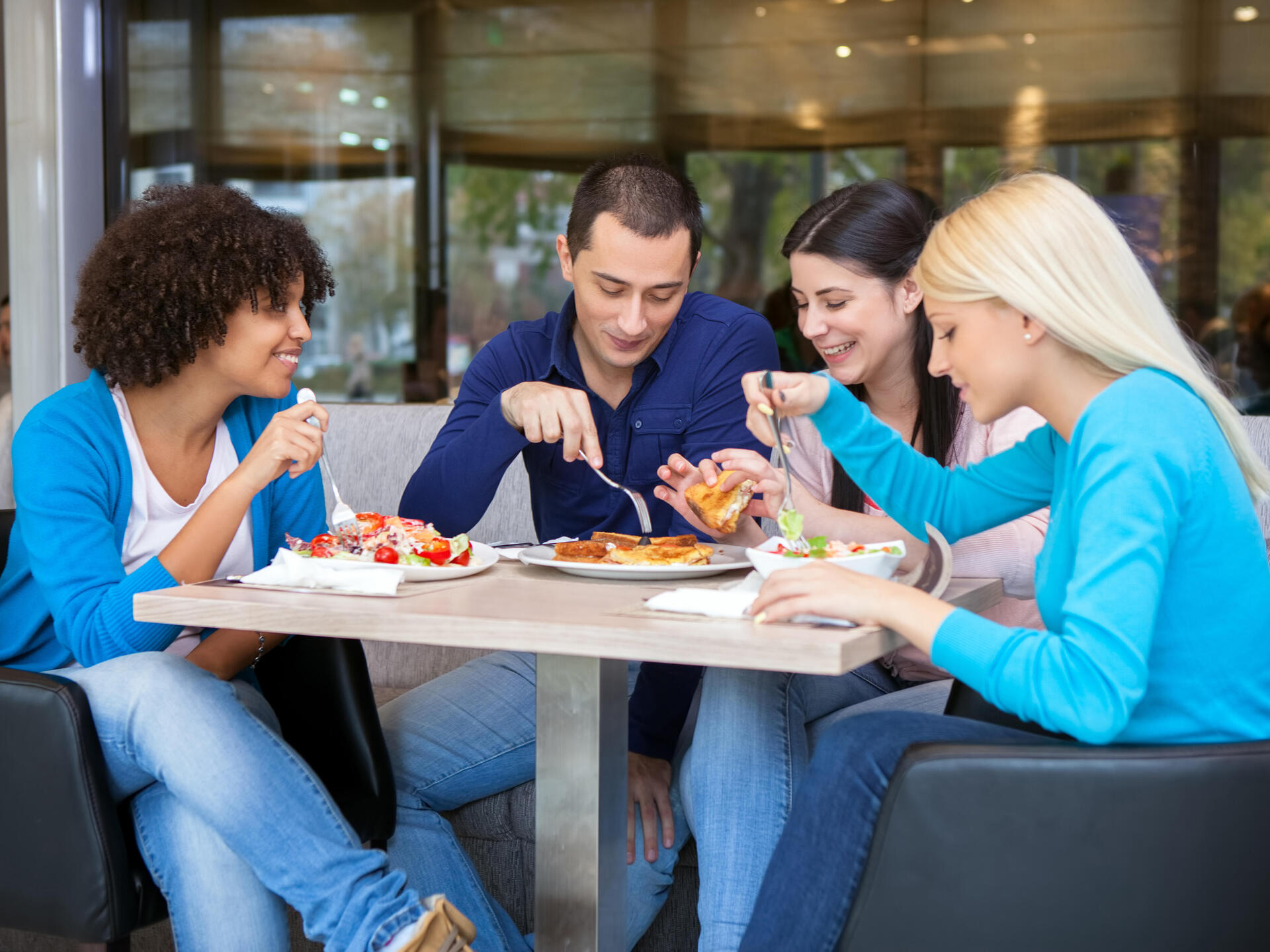 Studierende essen am Tisch zusammen zu Mittag