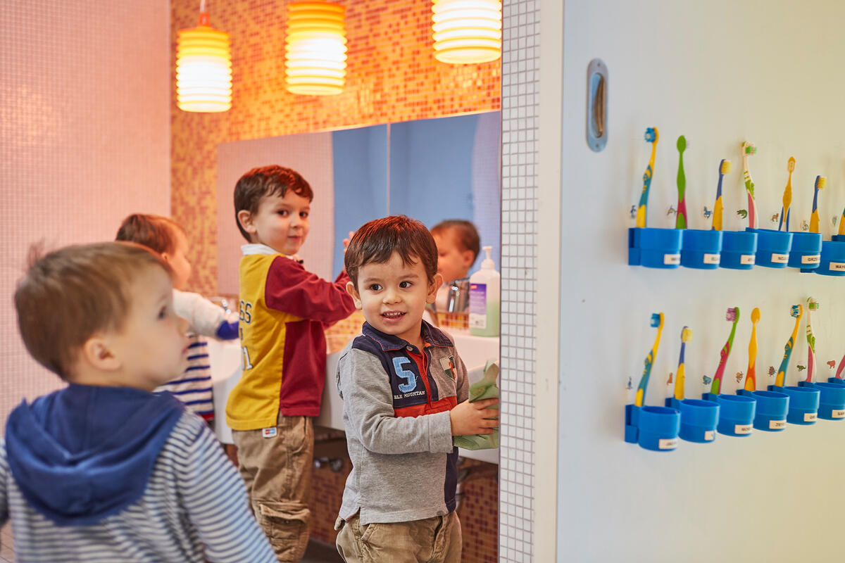 Four children are in the bathroom of the day care centre Abenteuerbande washing hands