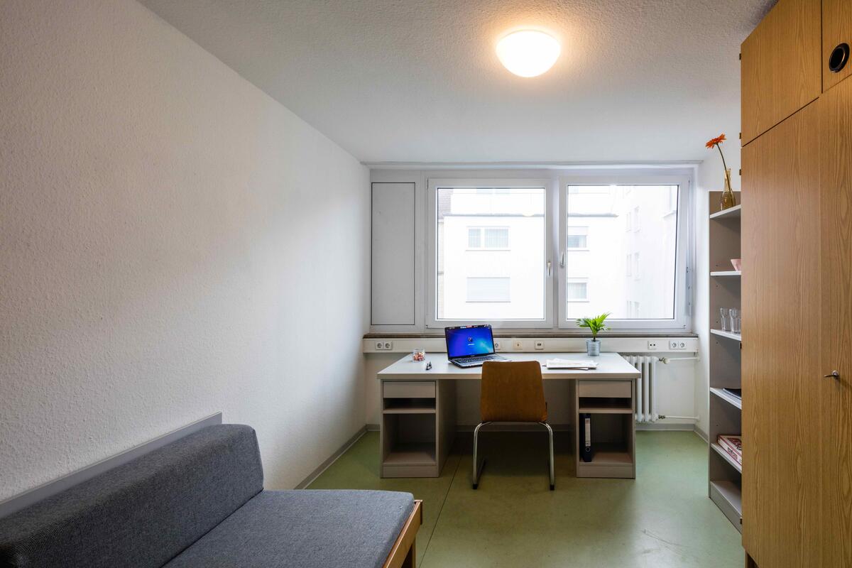 Zimmer mit Bett, Schreibtisch und Schrank im Theodor-Heus-Heim