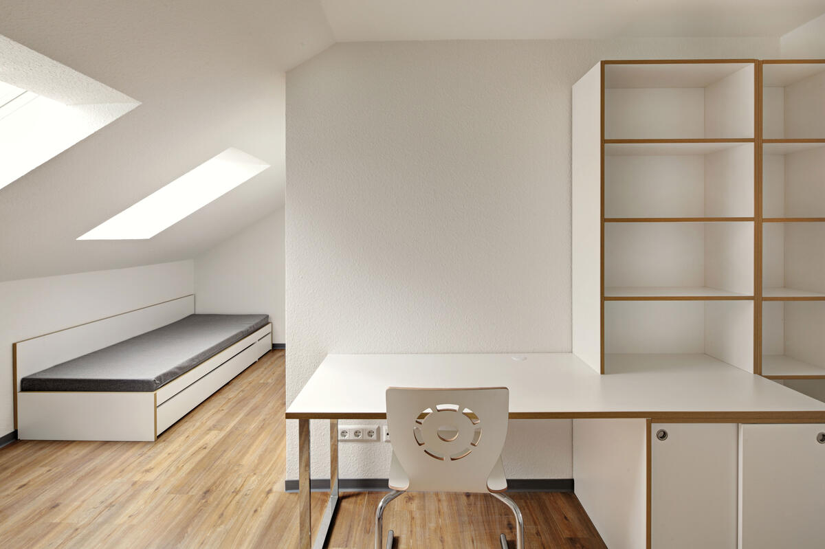 Zimmer mit Bett und Schreibtisch im Wohnheim in der Birkenwaldstraße