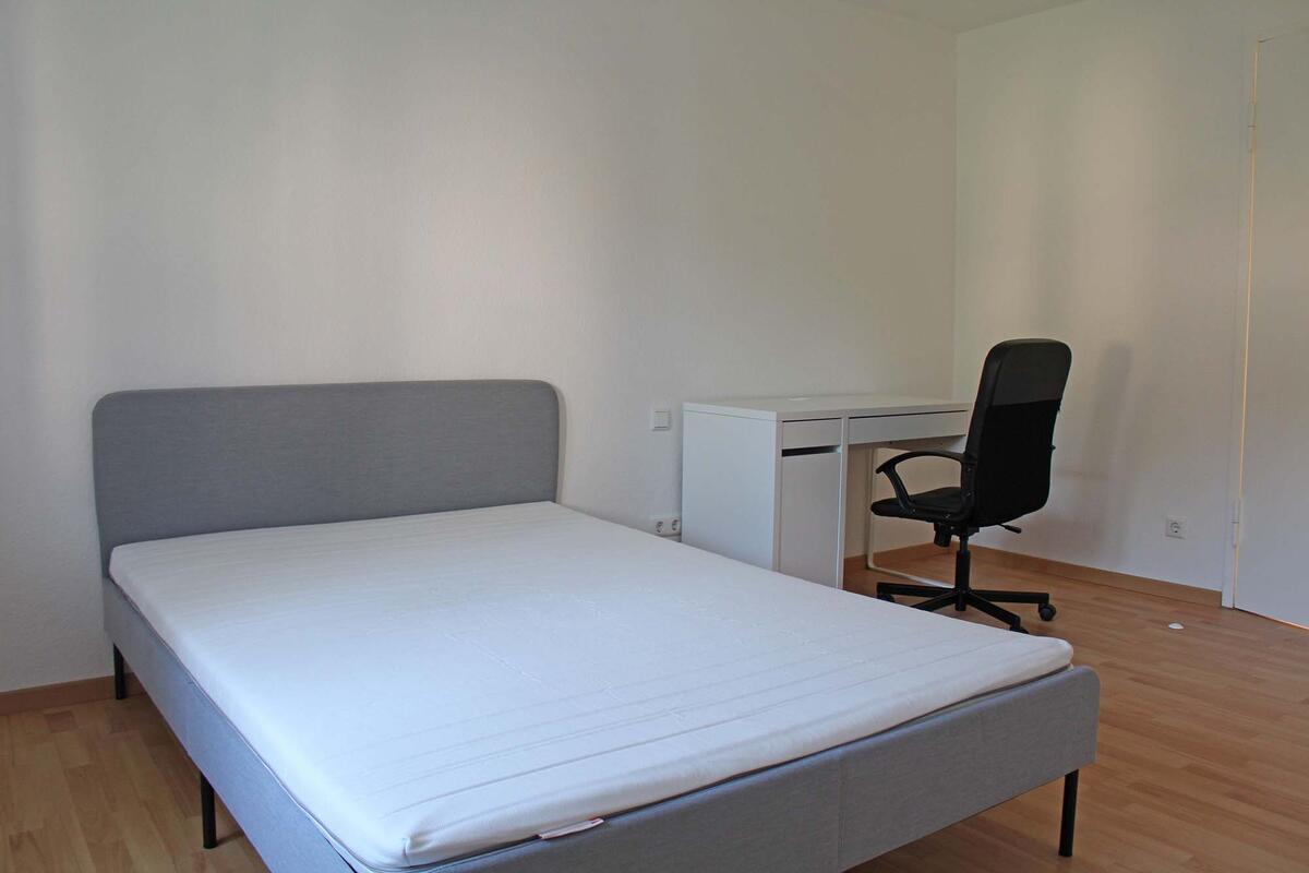 Zimmer mit Bett, Schreibtisch und Stuhl Außenansicht im Wohnareal in Stuttgart Rot