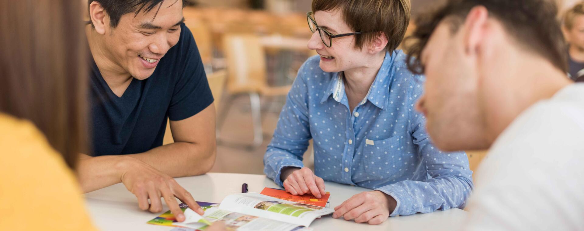 Woman advises a group of students at a table