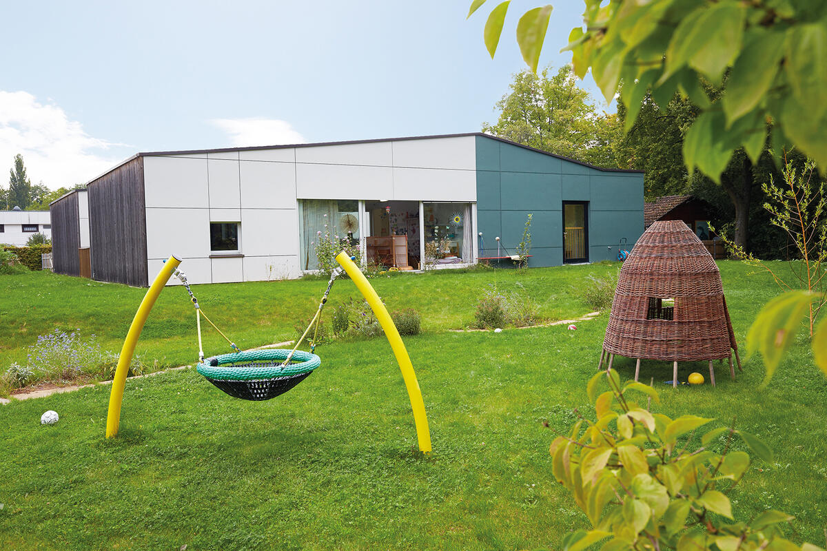 Child in garden with meadow and swing in day care center Pfaffenwald 