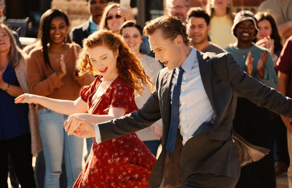 Szene aus dem Film The Life of Chuck: Ein Mann und eine Frau tanzen zusammen, während im Hintergrund zahlreiche Personen applaudieren