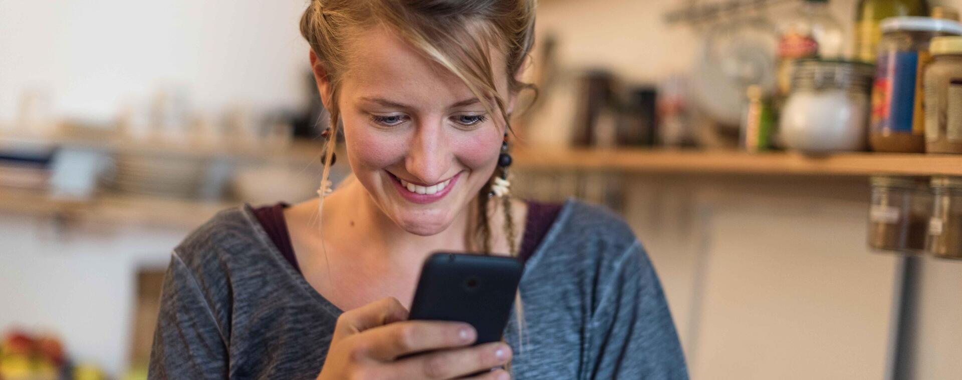 Junge Frau schaut auf ihr Handy