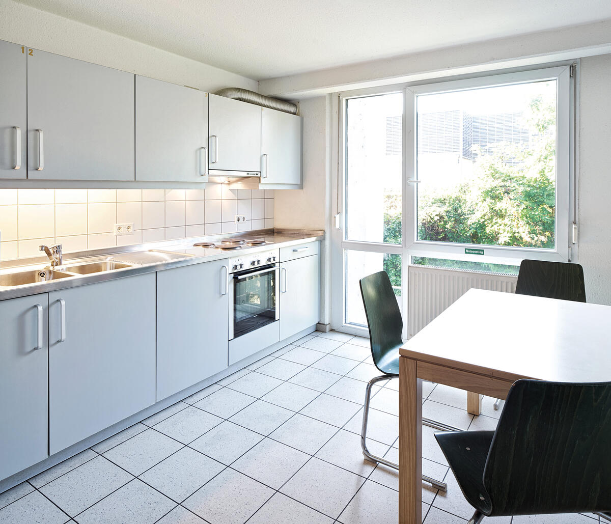 Kitchen with dining table and chairs in the dormitory In der Au