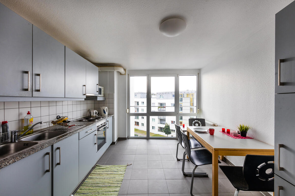 Kitchen with table, chairs and large window in the dormitory at Filderbahnplatz