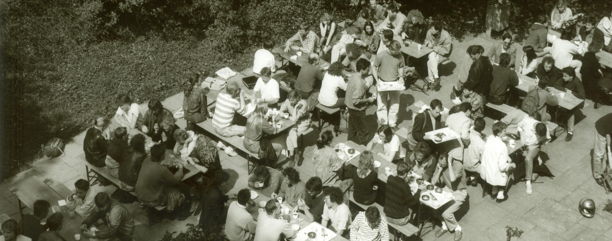 Historisches Schwarz-Weiß Foto von Studierenden die im Außenbereich der Mensa Essen