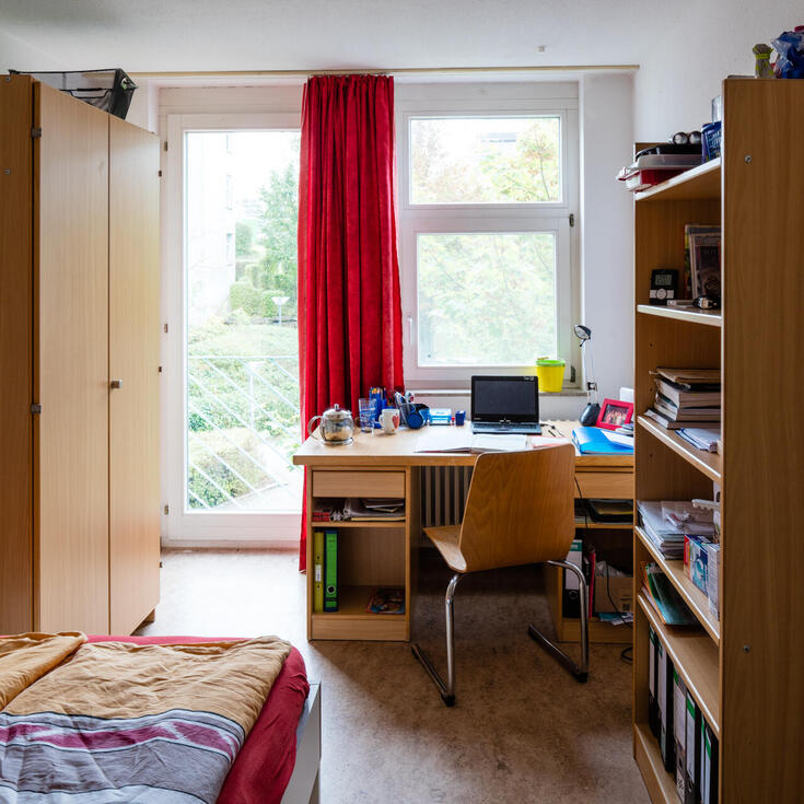 Zimmer mit Bett, Schrank und Schreibtisch im Allmandring 3