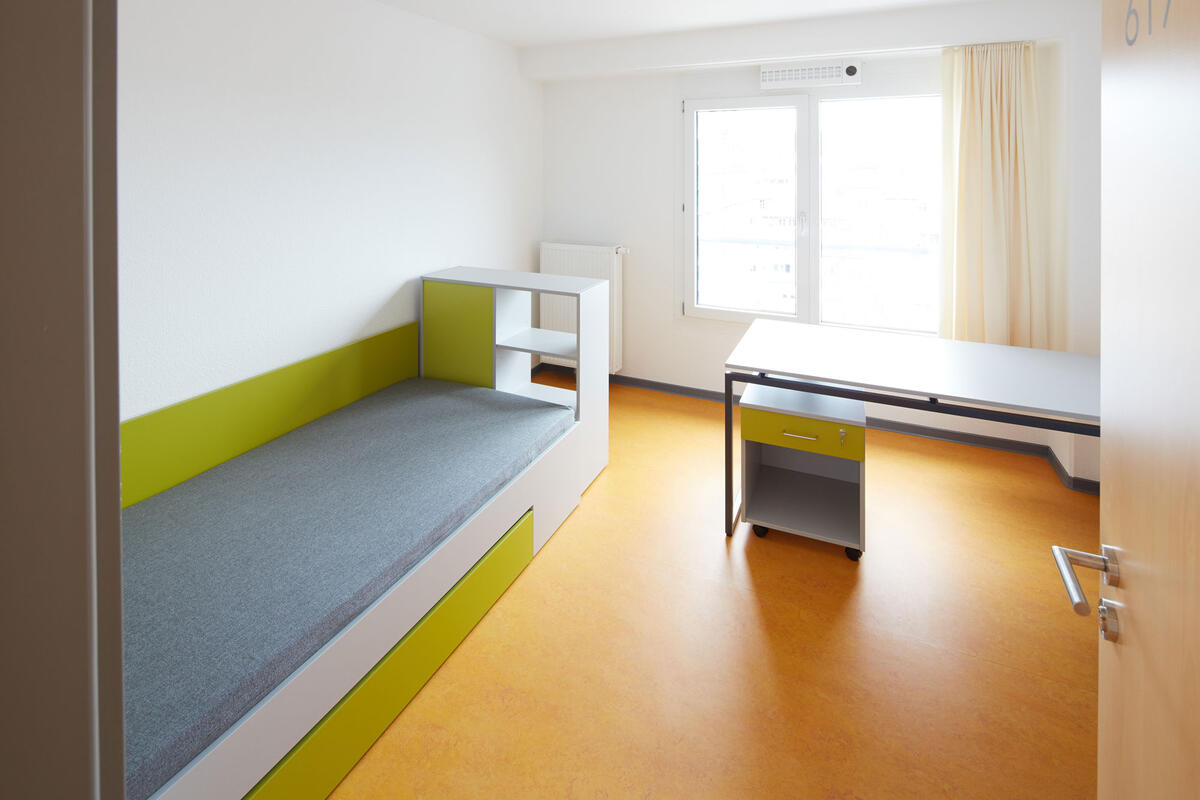  Zimmer mit Bett und Schreibtisch in der Wohnanlage im Rossneckar 1