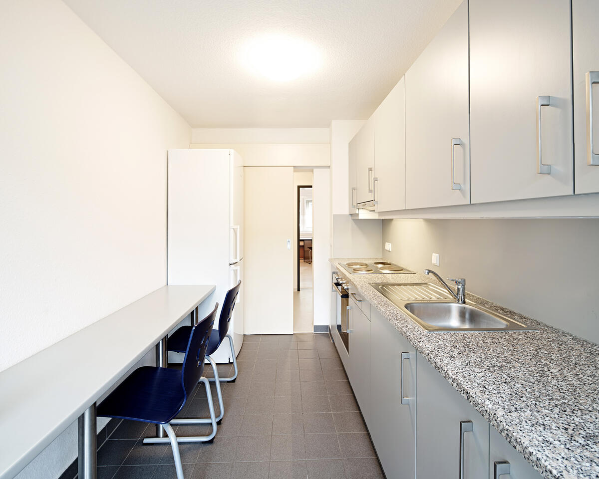 Kitchen with table and chairs in the dormitory at Rieckestraße