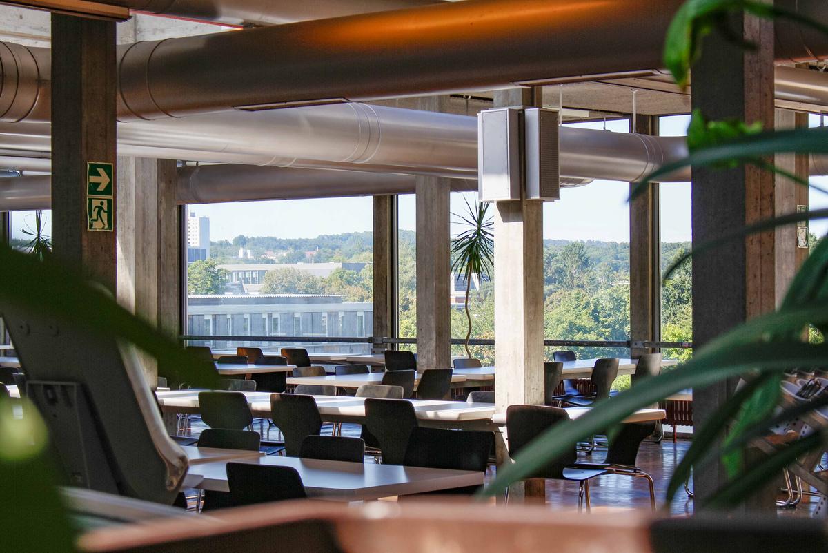 Essensaal mit grauen Säulen, Tische und Stühlen