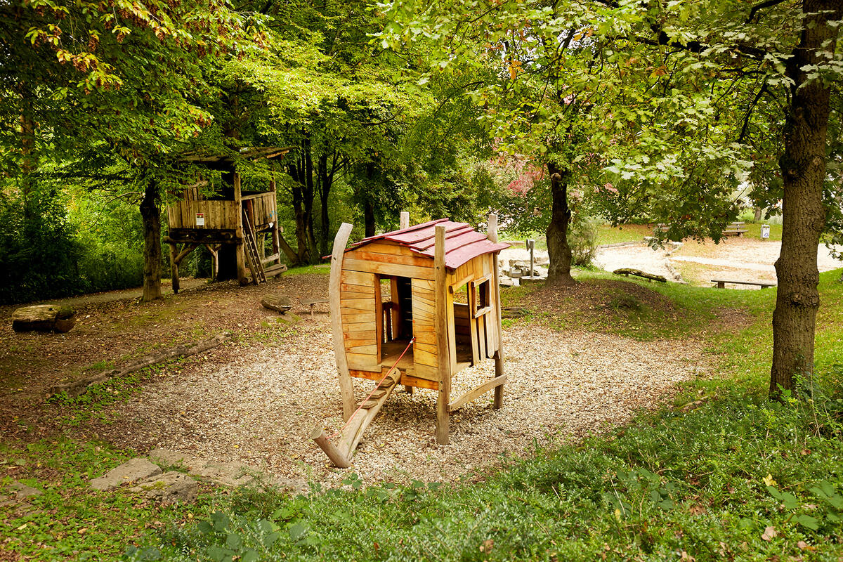 Foto von einem Holz-Spielhaus im Garten der in der Kita Krabbelmäuse