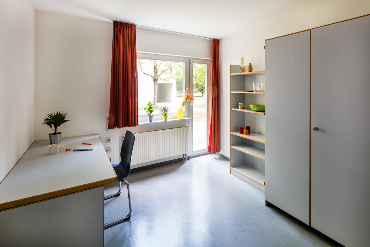 Room with desk, shelf and wardrobe in the dormitory Straußäcker 3 