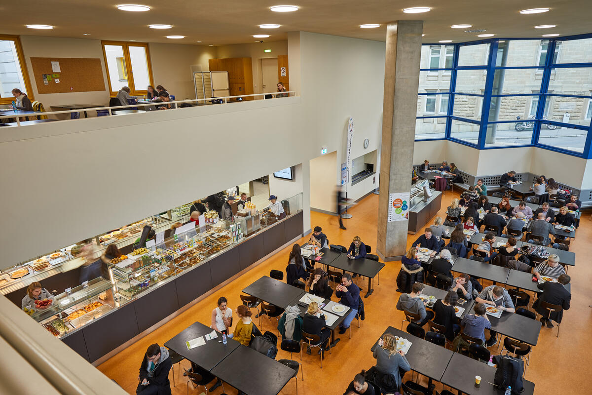 View from above of the dining area with tables, chairs and the counter of the Mensa Musikhochschule