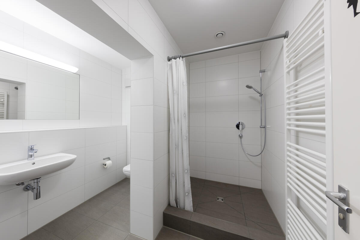 Bathroom with shower and washbasin in the Anna Herrigel dormitory