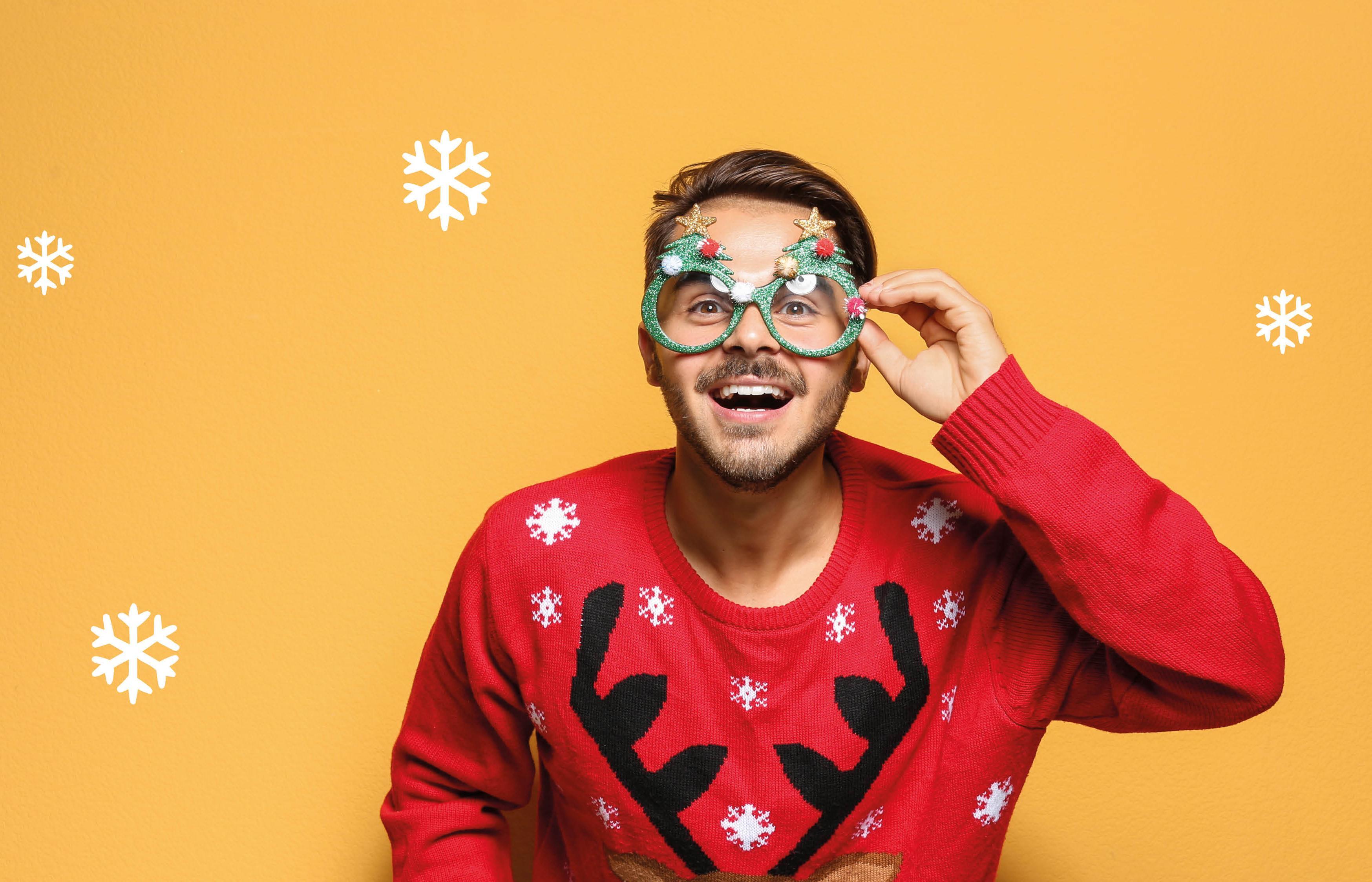 Mann mit rotem Weihnachtspulli und einer Weihnachtsbrille.