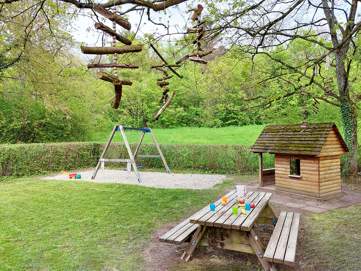 Garden of the Löwenzahn day-care centre with bench, little house and swing