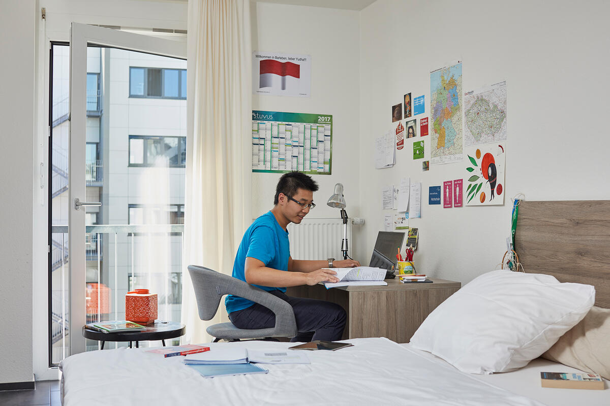 A student studies at a desk in a 1-room flat of the Boardinghaus Esslingen