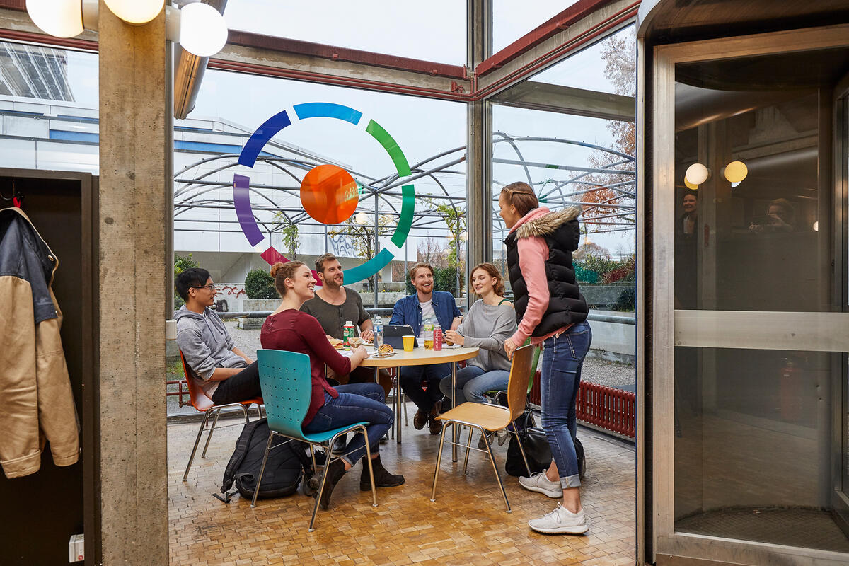 Studierende sitzen am Tisch in der Cafeteria in Vaihingen zusammen