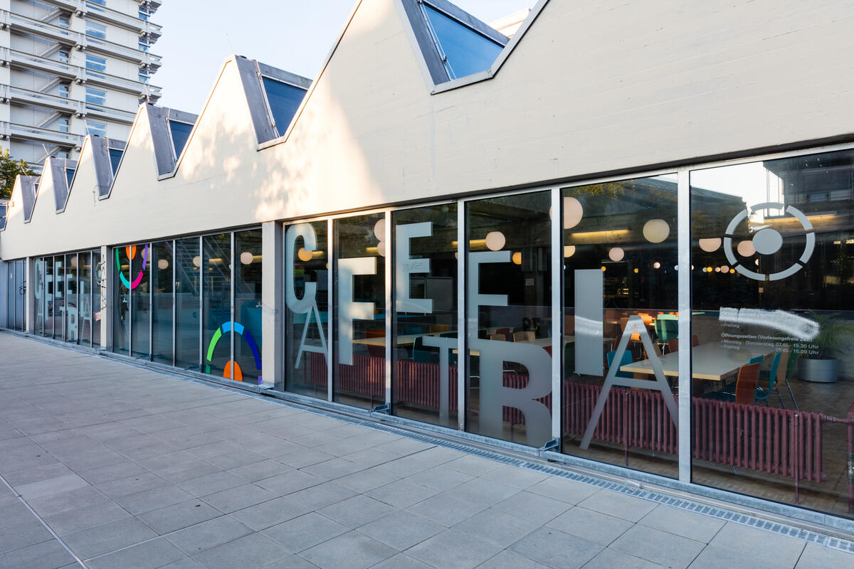 Außenansicht der Cafeteria Denkpause mit Schriftzug an der Scheibe