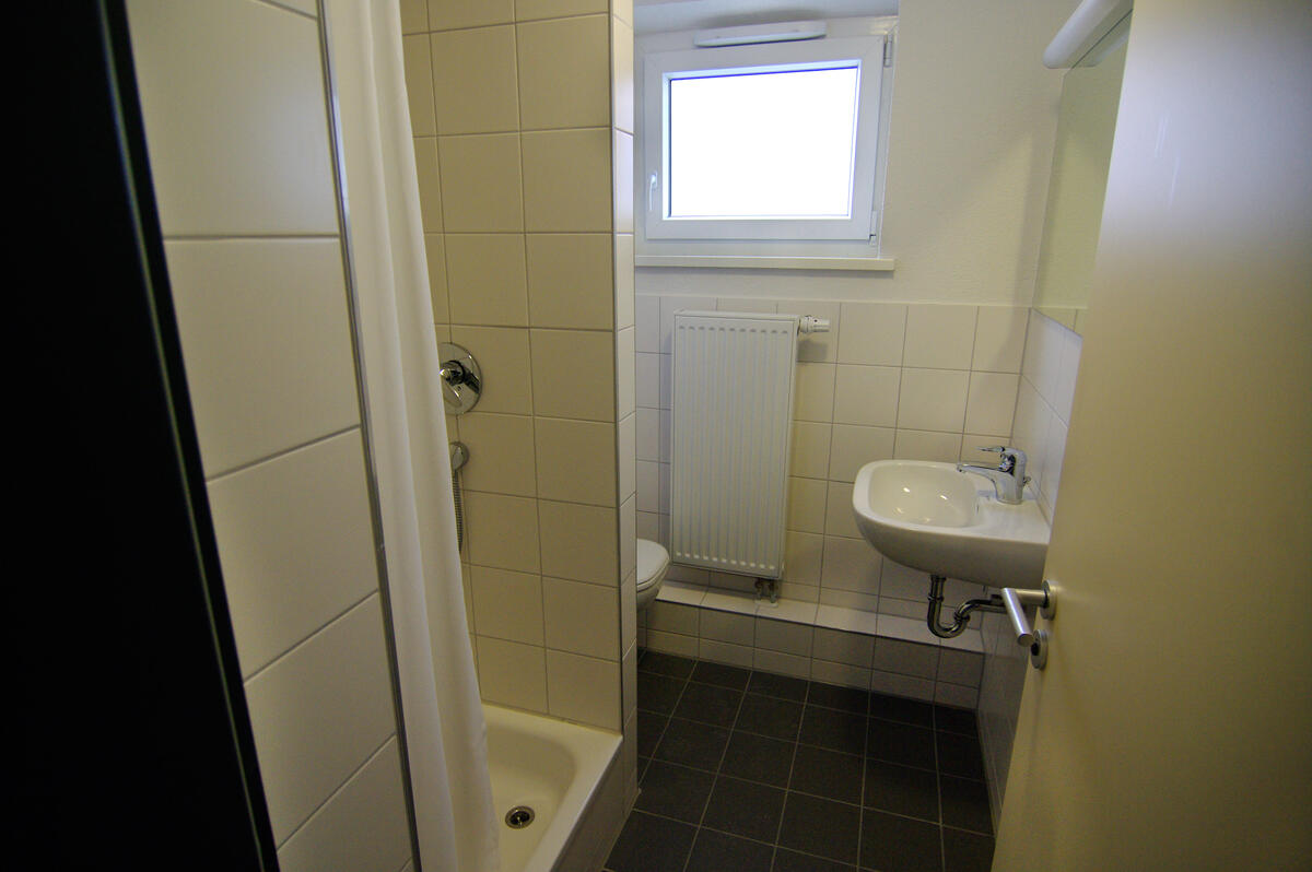 Bathroom with shower and sink in the dormitory at Rieckestraße
