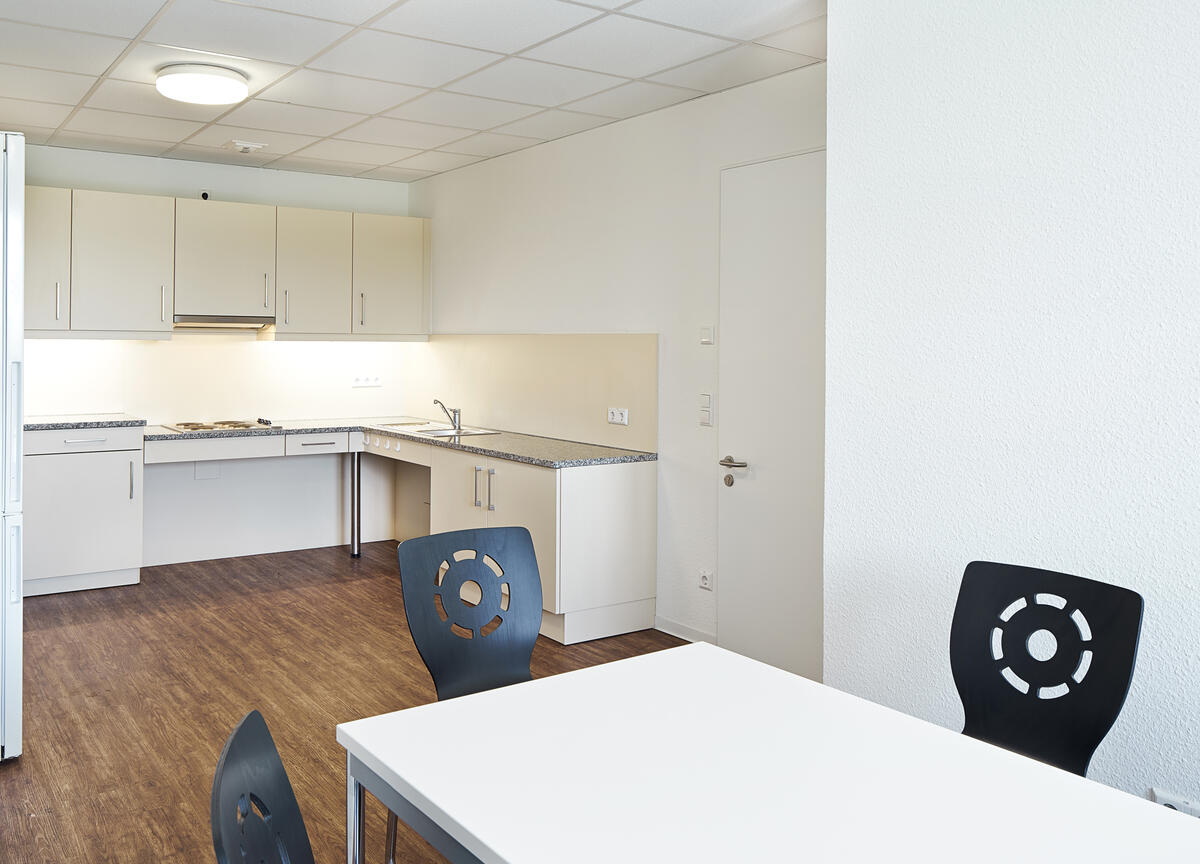 Kitchen with tables and chairs in the dormitory at Heilmannstraße 3