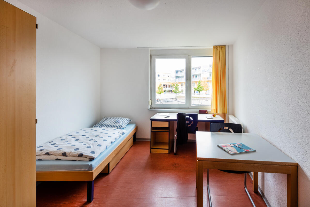 Room with bed, desk and wardrobe in the dormitory at Filderbahnplatz 